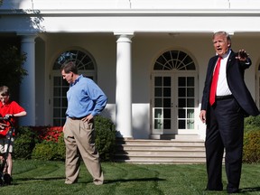 Frank Giaccio, 11, of Falls Church, Va., left, is assisted by a member of the National Park Service, and his father Greg Giaccio, as he gets back to mowing the lawn after President Donald Trump said goodbye, Friday, Sept. 15, 2017. (AP Photo/Jacquelyn Martin)