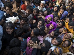 Desperate Rohingya grab for aid handouts of clothing and food on September 15, 2017 in Tankhali, Bangladesh. Nearly 400,000 Rohingya refugees have fled into Bangladesh since late August. Paula Bronstein/Getty Images