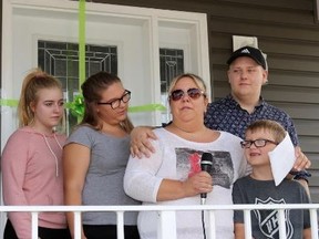 TIM MEEKS/THE INTELLIGENCER
Lynn Bassett fights back tears while being joined by her children Cassie, Hailey, Brett and Trent in thanking the hundreds of volunteers from Habitat for Humanity Prince Edward-Hastings who donated their time and skills to build her family's beautiful new home at 125 Donald St., Belleville on Friday.
