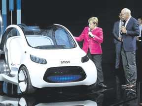 German Chancellor Angela Merkel and Dieter Zetsche, chairperson of Daimler AG, look at a Smart Vision EQ Fortwo autonomous electric concept car while visiting the Mercedes hall at the 2017 IAA Frankfurt Auto Show on Wednesday in Frankfurt am Main, Germany.  (Sean Gallup/Getty Images )