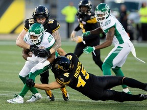 Saskatchewan Roughriders wide receiver Marcus Thigpen is tackled by Hamilton Tiger-Cats defensive end Connor McGough and linebacker Geoff Hughes during CFL action on Sept. 15, 2017. (THE CANADIAN PRESS/Peter Power)