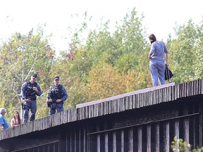 Greater Sudbury Police talk with a young women in emotional distress on the train bridge at Beatty Street in Sudbury on Friday. Police said the situation was safely resolved.