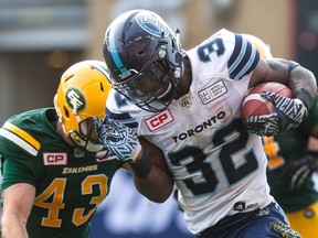 Toronto Argonauts running back James Wilder Jr. (right) is tackled by Edmonton Eskimos defensive back Neil King during the first half of CFL football action in Toronto on Saturday, September 16, 2017. THE CANADIAN PRESS/Chris Young