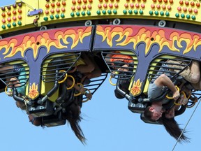 Rider pause at the top of the Fireball ride at the Kingston Fall Fair midway at the Memorial Centre in Kingston, Ont. on Saturday September 16, 2017. Steph Crosier/Kingston Whig-Standard/Postmedia Network