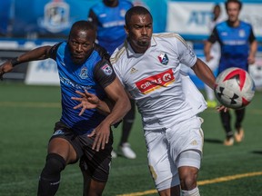 Sainey Nyassi of the FC Edmonton, tries to get past Jonathan Glenn of North Carolina FC at Clark Stadium on September 10, 2017.