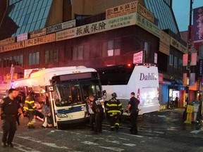 In this photo provided by the NYPD’s 109th Precinct, officers respond to a collision involving two buses on Main Street in the Queens borough of New York, Monday, Sept. 18, 2017. (NYPD’s 109th Precinct via AP)