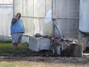 Joe Young, right, joins Henry and Lisa Dyck and their baby, Jocelyn, as they grieve friends killed after their vehicle hit a concrete barrier and ruptured a carbon dioxide tank, which exploded, at a rural Leamington greenhouse early Sunday. (NICK BRANCACCIO/Postmedia News)