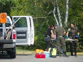 Quebec provincial police officers search for evidence next to a truck in Lachute, Quebec on Friday, September 15 , 2017. (THE CANADIAN PRESS/Graham Hughes)