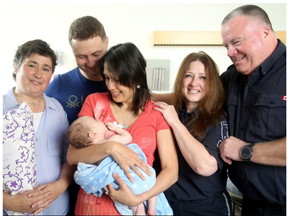 Yury and Oksana Shelkovyy - the parents of three-month-old Nikita, who was saved last week by strangers who gave their son CPR - greet their heroes at CHEO Monday. They include PSW Geraldine Carvalho (left), ambulance dispatcher Sandra Dinel (second from right) and City of Ottawa parking officer, David McEvoy (far right). (JULIE OLIVER / POSTMEDIA)