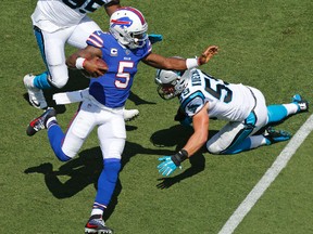 Buffalo Bills' Tyrod Taylor runs past Carolina Panthers' Charles Johnson and Luke Kuechly in the first half of an NFL football game in Charlotte, N.C., on Sept. 17, 2017. (AP Photo/Jason E. Miczek)