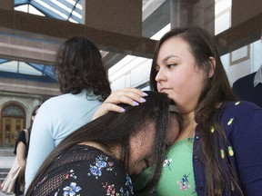 Francie Munoz sheds a tear on sister Yasmin's shoulder as they prepare to leave Toronto Police headquarters on Tuesday, September 19, 2017. (Stan Behal/Toronto Sun)