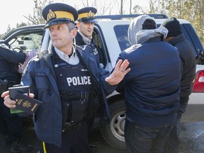 RCMP officers detain a group of asylum seekers who crossed from the U.S. into Canada illegally at the border at Roxham Road in Hemmigford south of Montreal, Monday February 20, 2017. (Phil Carpenter/MONTREAL GAZETTE)
