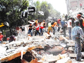 People remove debris of a collapsed building looking for possible victims after a quake rattled Mexico City on September 19, 2017. / AFP PHOTO / Omar TORRESOMAR TORRES/AFP/Getty Images