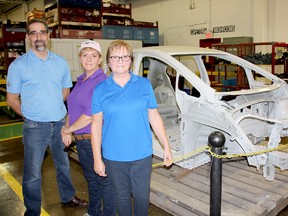Martinrea Ridgetown celebrated its 30th anniversary on Saturday. From left are general manager Don Gillier, production supervisor Deborah Langham, and Ruth Roos, of human resources. They're standing in front of a frame for the Chevrolet Bolt, a fully electric vehicle. Next year, the company will begin supplying parts for driverless vehicles.