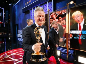 Alec Baldwin, winner of the award for outstanding supporting actor in a comedy series for "Saturday Night Live", left, walks with James Corden on the red carpet stage at the 69th Primetime Emmy Awards on Sunday, Sept. 17, 2017, at the Microsoft Theater in Los Angeles. (Photo by Danny Moloshok/Invision for the Television Academy/AP Images)