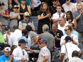 Baseball fans reacts as a young girl is carried out of the seating area after being hit by a line drive during the fifth inning of a baseball game between the New York Yankees and Minnesota Twins, Wednesday, Sept. 20, 2017, at Yankee Stadium in New York. (AP Photo/Bill Kostroun)