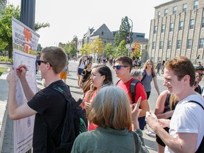 The local chapter of Peace Quest, a national grassroots organization that works towards peace-building initiatives across Canada, is seen Wednesday on the corner of University and Union streets in the heart of the Queen’s University district, looking for people to sign the International Treaty to Ban Nuclear Weapons. (Julia McKay/The Whig-Standard)