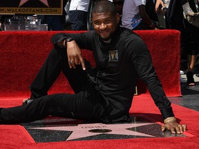 Usher sits on his star on the Hollywood Walk of Fame star in Hollywood, Calif., in this 2016 file photo. (MARK RALSTON/AFP/Getty Images)