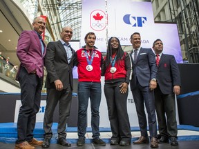 Jason Anderson (from left), Senior Vice President, Marketing, Cadillac Fairview, John Sullivan, CEO, Cadillac Fairview, Canadian Olympic medalists - Dylan Moscovitch and Shelley-Ann Brown - Chris Overholt, CEO & Secretary General, Canadian Olympic Committee and Derek Kent, Chief Marketing Officer, COC pose for a photo at an event at the Eaton Centre in Toronto on Sept. 20, 2017. (Ernest Doroszuk/Toronto Sun/Postmedia Network)