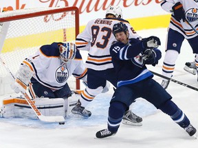 Winnipeg Jets' Matt Hendricks (15) attempts to get the rebound off Edmonton Oilers goaltender Laurent Brossoit (1) as Matthew Benning (83) defends during first period NHL pre-season game action in Winnipeg on Wednesday, September 20, 2017.