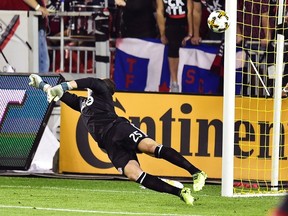 Toronto FC goalkeeper Alex Bono lets in a goal by Montreal's Marco Donadel during Wednesday night's game. (THE CANADIAN PRESS)