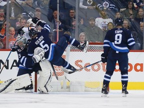 Jets’ Dmitry Kulikov crashes into goalie Steve Mason during the second period at the Bell MTS Place last night. (The Canadian Press)