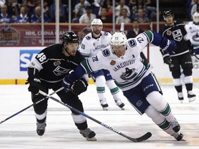 Daniel Sedin of the Vancouver Canucks (right) and Oscar Fantenberg of the Los Angeles Kings fight for the puck during the NHL China preseason hockey game at Mercedes-Benz Arena in Shanghai, China, on Thursday, Sept. 21, 2017. (AP Photo)