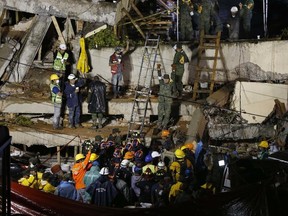 Rescue personnel work to rescue a trapped child at the collapsed Enrique Rebsamen primary schoool in Mexico City, Sept. 20, 2017. (AP Photo/Marco Ugarte)