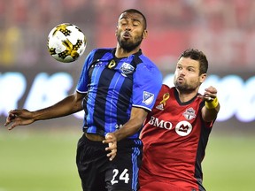 Montreal Impact’s Anthony Jackson-Hamel battles for the ball with Toronto FC’s Drew Moor on Wednesday. (THE CANADIAN PRESS)