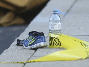 A pair of shoes, a toy car and a water bottle lay next to police tape at the scene where a young child died after being left alone inside a hot car parked in Etobicoke on Thursday, Sept. 21, 2017. (JACK BOLAND/TORONTO SUN)