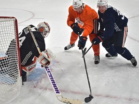 Edmonton Oilers Ben Betker (76) and Jussi Jokinen (36) fight for the puck in front of goalie Nick Ellis during the first day of training camp at Rogers Place in Edmonton, September 15, 2017.