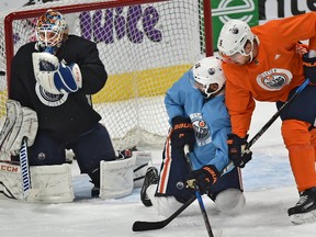 Edmonton Oilers goalie Cam Talbot makes a save as Jujhar Khaira (16) and Adam Larsson (6) get tangled up at practice during training camp at Rogers Place Edmonton, September 21, 2017.
