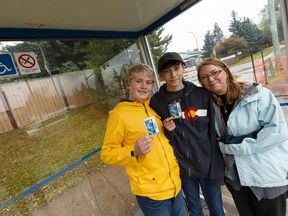 Lita Bablitz (centre) is seen with her sons Pearson (left), 12, and Jasper, 15, at the bus stop they use to attend school at Avalon Junior High School and Harry Ainlay High School respectively in Edmonton, Alberta on Thursday, September 21, 2017.