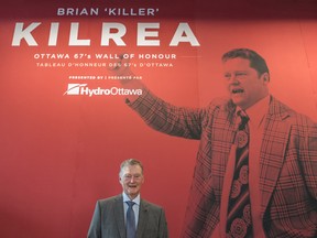 Former 67’s coach Brian Kilrea poses in front of the Brian Kilrea Legacy Wall at The Arena at TD Place. ( Valerie Wutti/Blitzen Photography)