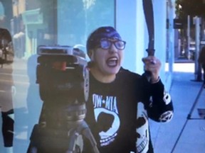 In this Thursday, Sept. 21, 2017, video image released by the Los Angeles County Sheriff's Department, a suspect waves a machete at news reporters outside the Kardashian-owned DASH boutique in West Hollywood, Calif. (Los Angeles County Sheriff's Department via AP)