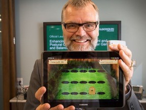 Dr. Frank Knoefel with the tablet game based on whack-a-mole. WAYNE CUDDINGTON / POSTMEDIA