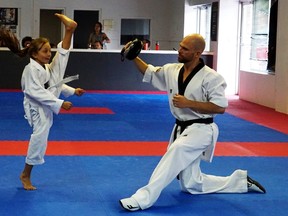 Nine-year-old white belt Sienna Perry practices an axe kick with Master Mark Warburton at the Sarnia Olympic Taekwondo Academy.
Handout/Sarnia This Week