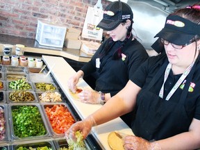 Tara Waite and Koreen Amon work feverishly over the lunch hour to fill orders placed at Pita Pit in Welland. (File photo)