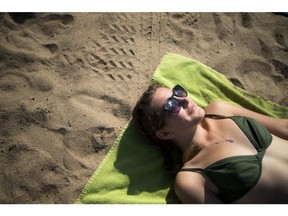 Savannah Greene soaks up the sunshine and the warm weather at Mooney’s Bay beach Saturday, September 23, 2017. Ashley Fraser/Postmedia