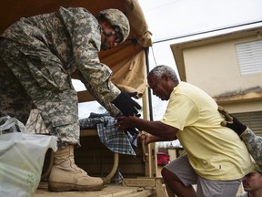 National Guard personnel evacuate Toa Ville resident Luis Alberto Martinez after the passing of Hurricane Maria, in Toa Baja, Puerto Rico, on Friday, Sept. 22, 2017. (Carlos Giusti/AP Photo)