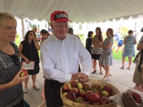 Outgoing Gov.-Gen. David Johnston checks out some fresh apples at the Savour Fall event at Rideau Hall on Saturday.