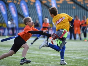 Two players take part in the CFL/NFL Flag Football initiative at Commonwealth Stadium on Saturday, Sept. 24, 2017.