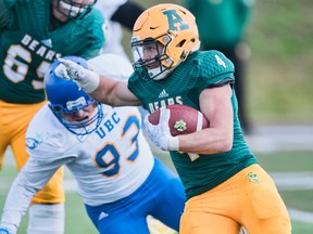 University of Alberta Golden Bears running back Edward Ilnicki avoids a tackle from UBC defensive lineman Nico Repole during a Canada West football game at Foote Field on Saturday, Sept. 23, 2017