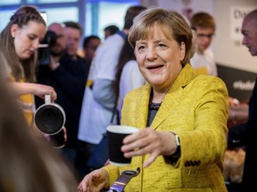 German chancellor Angela Merkel drinks a cup of coffee with election campaign workers in Berlin, Saturday, Sept. 23, 2017 ahead of Germany's election on Sunday. (Michael Kappeler/dpa via AP)