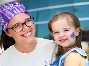 Tim Miller/The Intelligencer
Kaitlyn Bell sits with her niece, Holly Dowling, at the face-painting booth at the 8th Annual Sarcoma Step and Fetch on Sunday in Trenton. The event was originally created by Teresa Bell, Kaitlyn and Holly’s mother and grandmother (respectively). Teresa Bell died in December of last year and organizers say Saturday’s event was about celebrating her life.