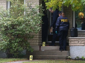 Winnipeg police identification unit officers observe the scene on Madrigal Close in the Maples area of Winnipeg on Sun., Sept. 24, 2017. A tactical support unit officer was stabbed and a 33-year-old suspect shot after police responded to a stabbing report late Saturday afternoon. The suspect died in hospital while the officer, who sustained an upper body injury, was in hospital in stable condition. Kevin King/Winnipeg Sun/Postmedia Network