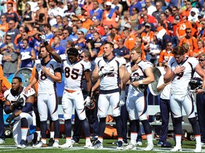 Broncos tight end Virgil Green (85) gestures as teammate Max Garcia (left) takes a knee during the playing of the U.S. anthem prior to an NFL game against the Bills in Orchard Park, N.Y., on Sunday, Sept. 24, 2017. (Adrian Kraus/AP Photo)