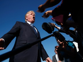 President Donald Trump speaks with reporters before boarding Air Force One at Morristown Municipal airport, Sunday, Sept. 24, 2017, in Morristown, N.J. (AP Photo/Evan Vucci)