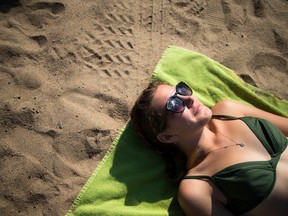 Savannah Greene soaks up the sunshine and the warm weather at Mooney's Bay beach.