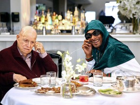 In this image released by AARP Studios, Don Rickles, left, and Snoop Dogg listen to music during an appearance on Rickles' 13-episode series “Dinner with Don." Rickles, who died in April of kidney failure at age 90, interviews celebrities such as Jimmy Kimmel, Snoop Dogg, Robert De Niro and Martin Scorsese at his favorite restaurants in Hollywood. The series can be seen on AARP’s digital platform DinnerWithDon.com (Sean Costello/Dinner With Don/AARP Studios via AP)